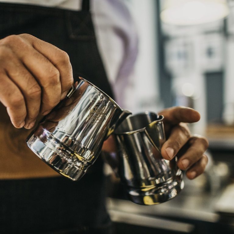 Barista professionnel Bacio préparant un cappuccino avec latte art italien authentique.